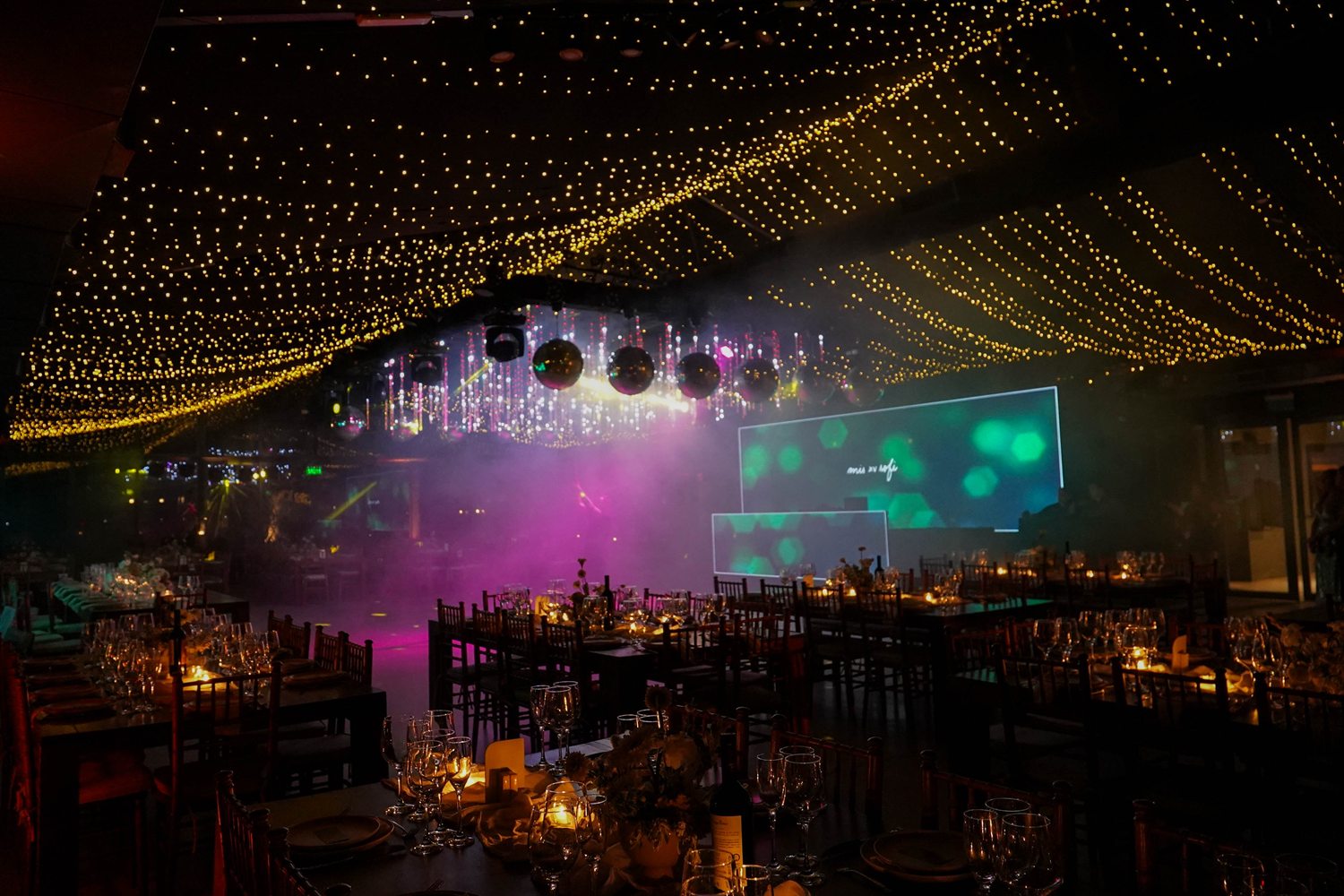 El salón de Estancia El Recuerdo montado para una fiesta de noche, con cielo de luces