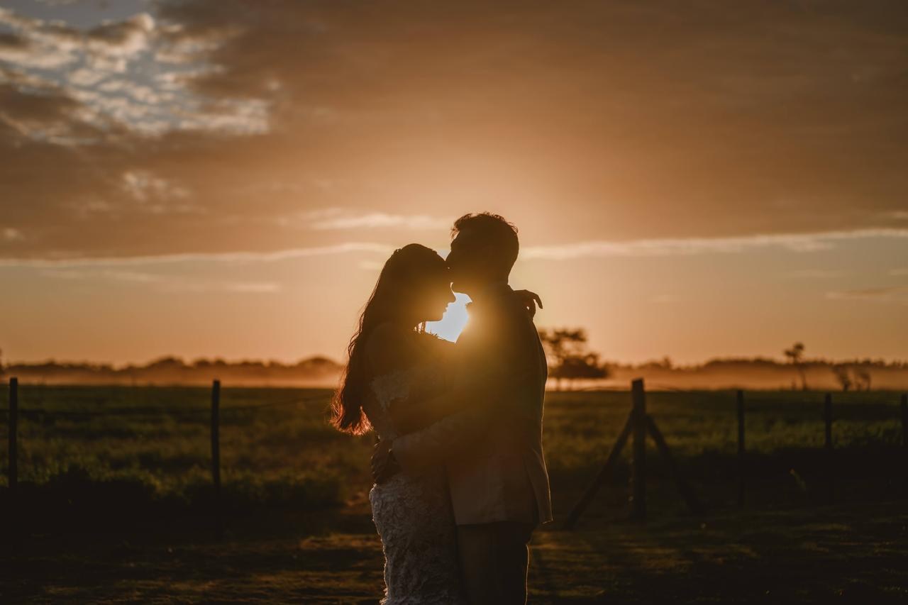 Novios al atardecer sobre el campo abierto