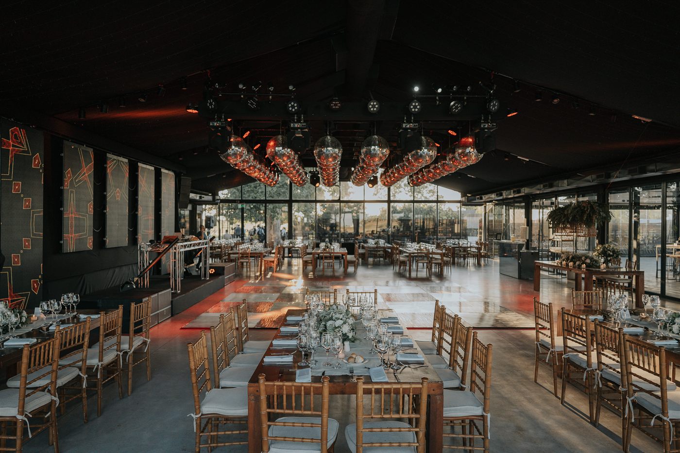 El salon montado con mesas largas y luces calidas