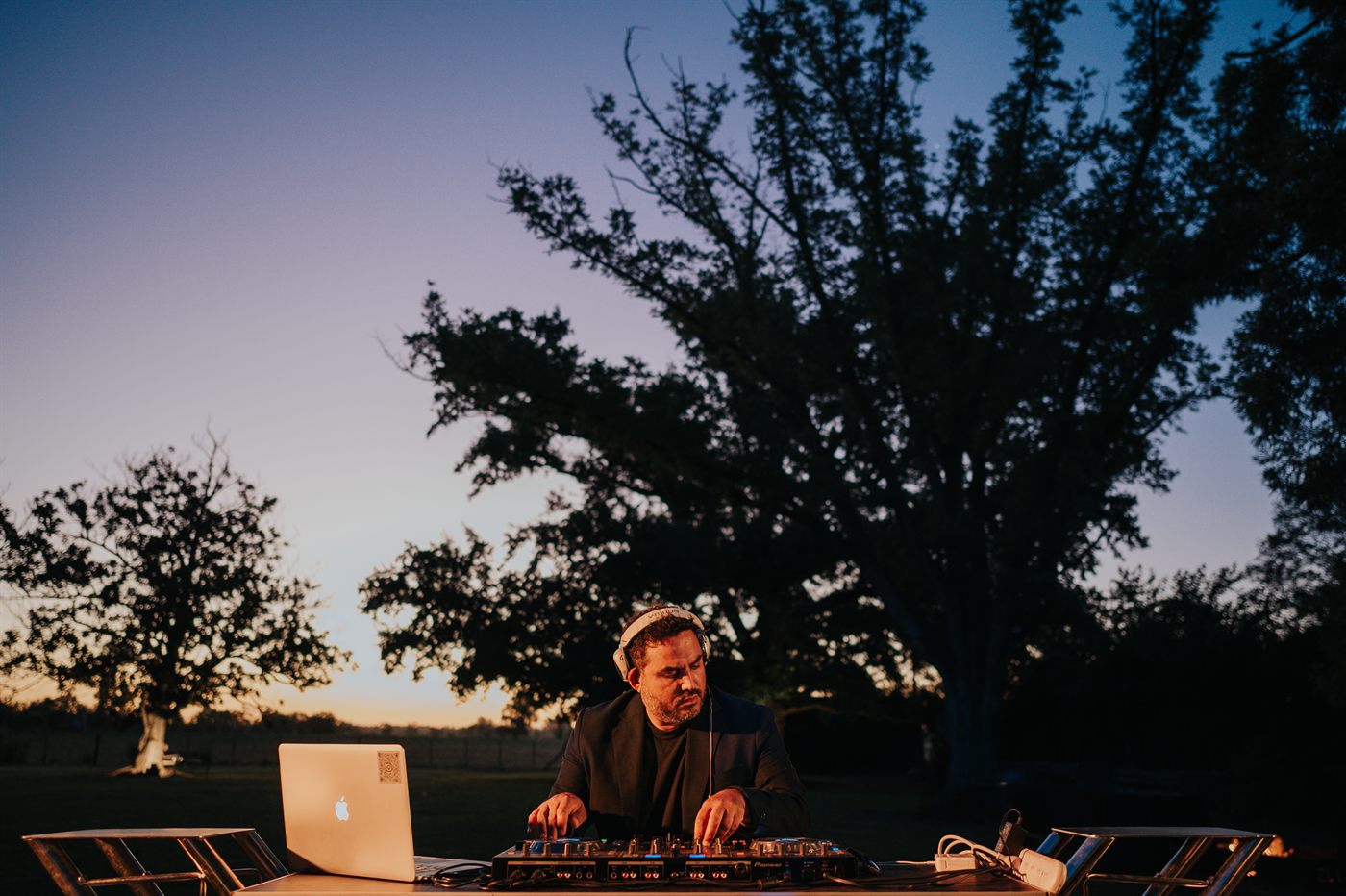 DJ tocando al atardecer bajo el &aacute;rbol