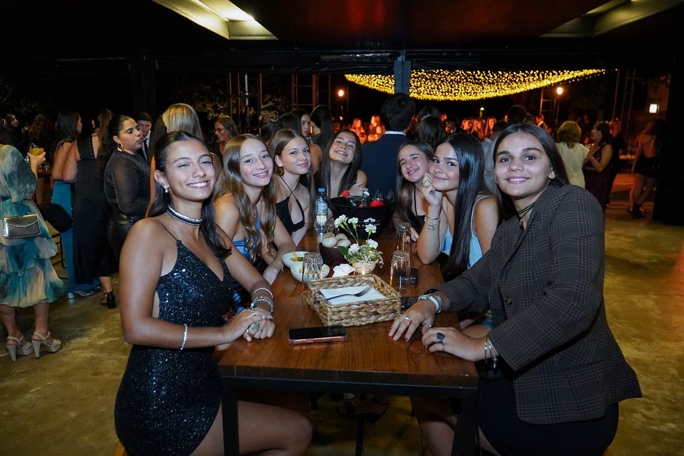 Las amigas en la mesa, bajo las guirnaldas de la recepción