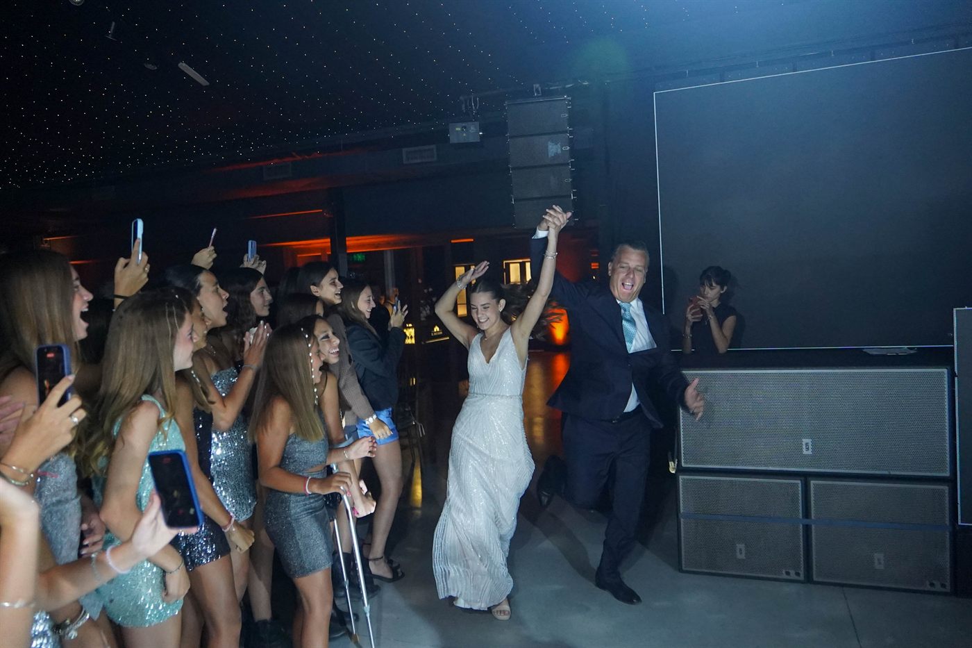 La entrada de la quinceañera con su papá, las amigas filmando